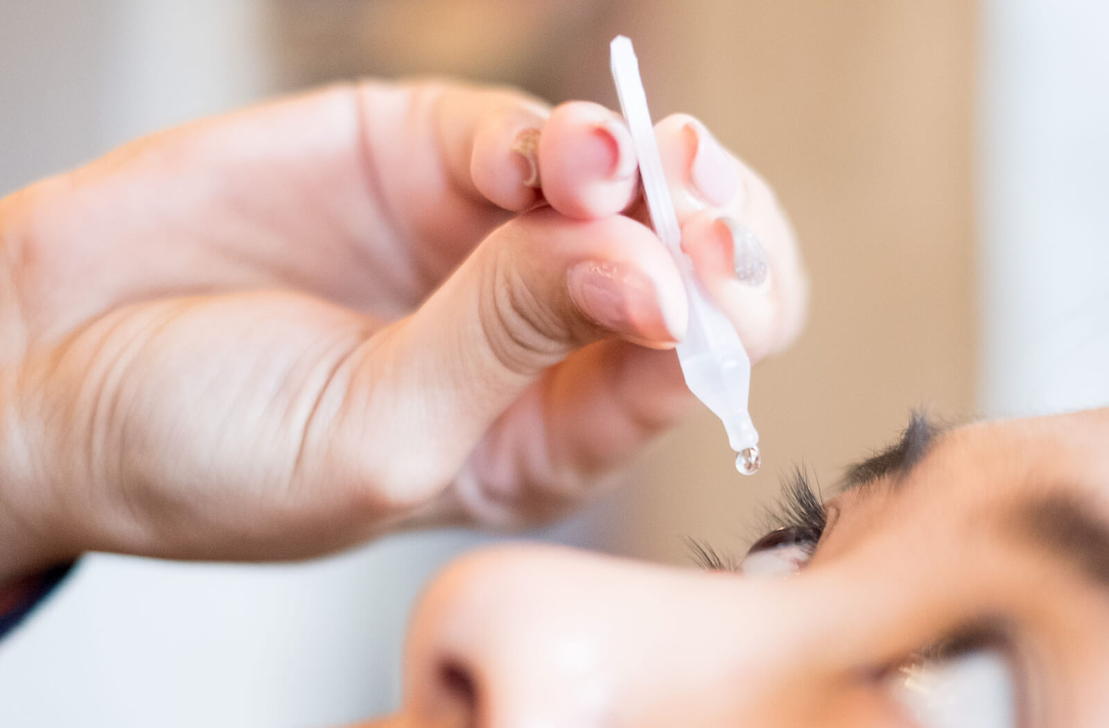 a person with dry eye uses eye drops for relief