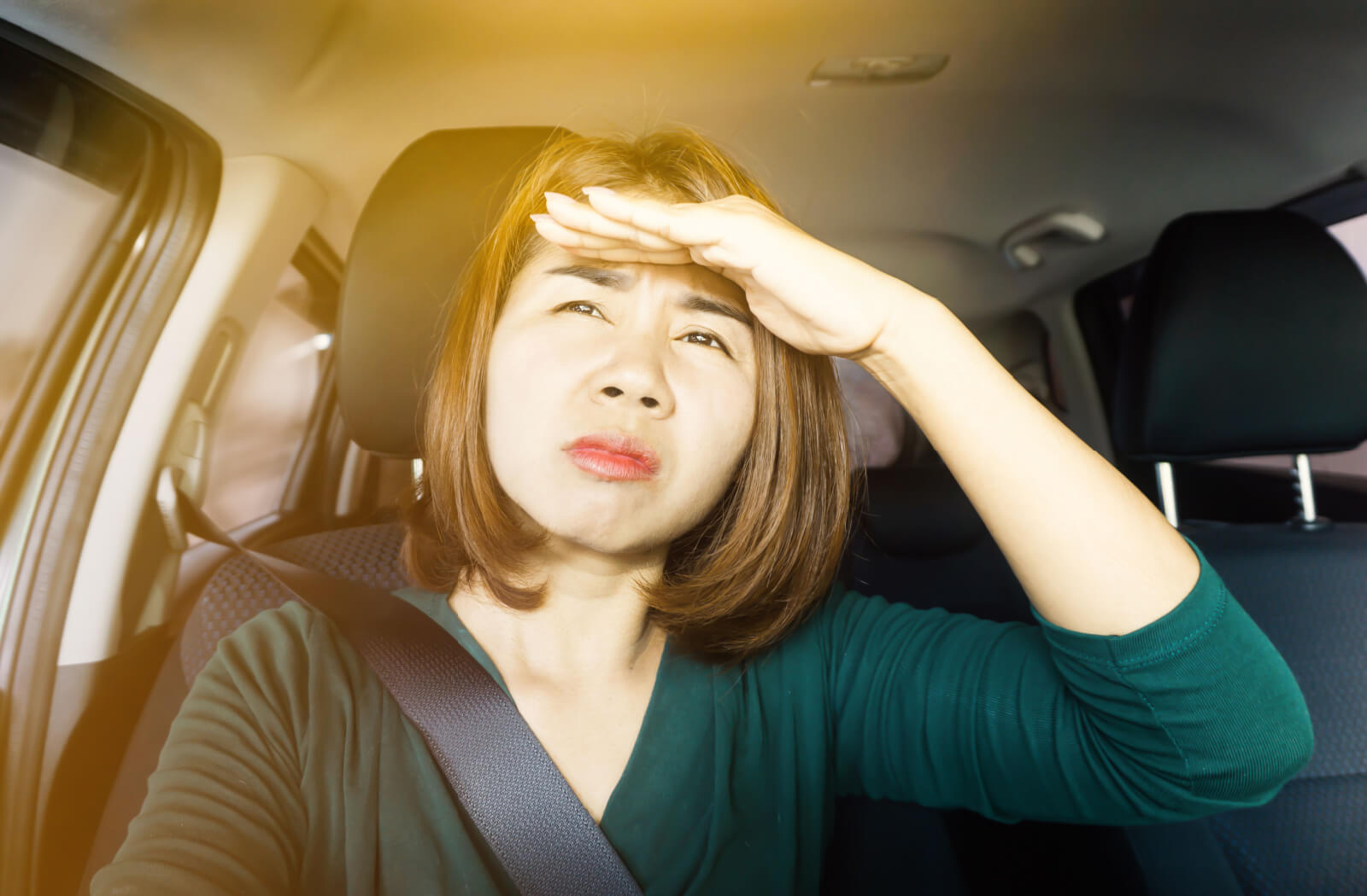 A woman driving her car is struggling due to blurred vision