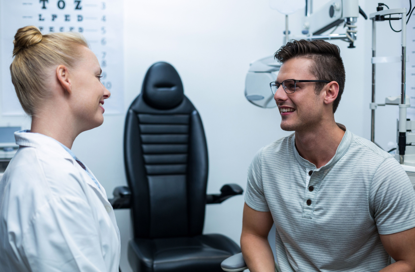 A female optometrist interacting with young man in an optical clinic