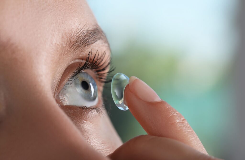 A close-up of an individual inserting their contact lens.