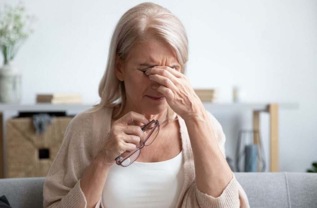Older woman rubbing her eyes while appearing to experience discomfort.