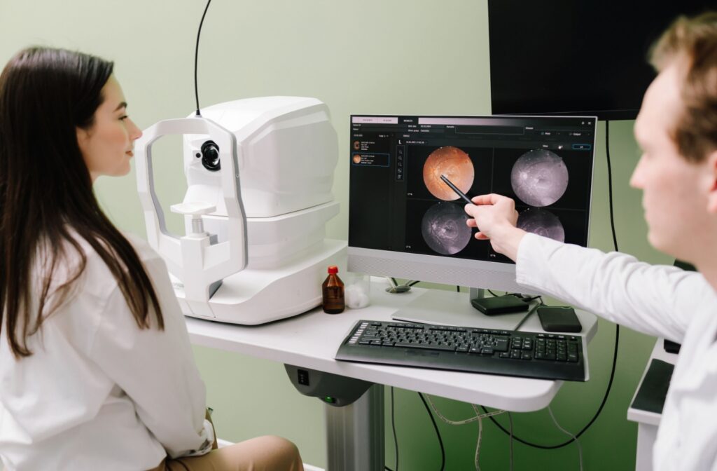 An eye doctor evaluates a patient's retinal photos during a routine eye exam for glaucoma screening.